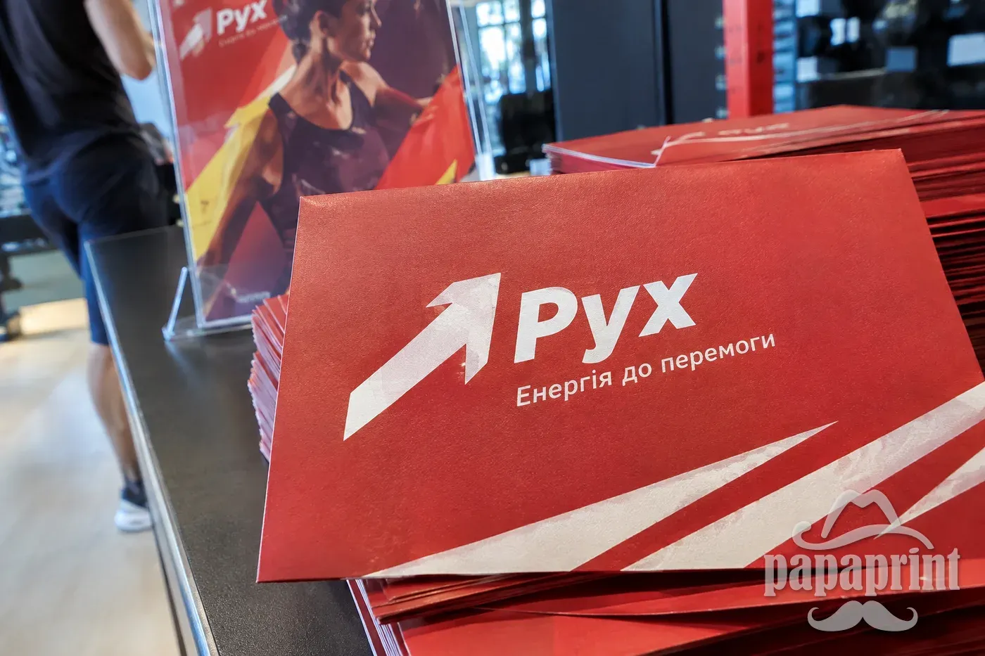 Запрошення спортклубу Рух з білим друком на червоному картоні