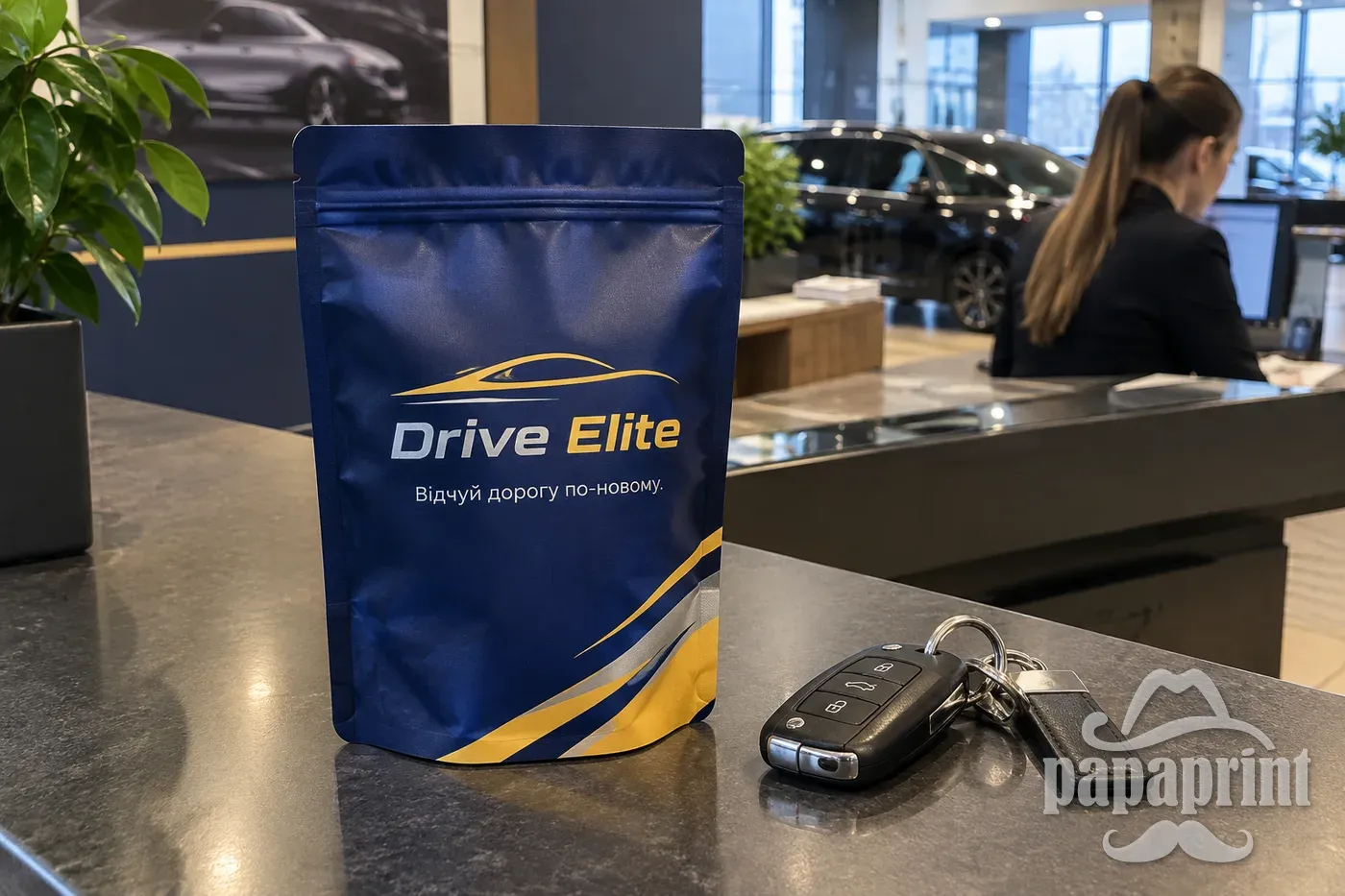 Дой-пак з логотипом 'Drive Elite' на столі автосалону