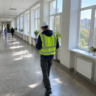 Виконроб з планшетом обходить ряд вікон у коридорі лікарні (ілюстрація)